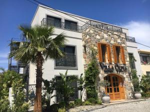 a white house with a palm tree in front of it at Villa Oliva Butik Hotel in Bodrum City