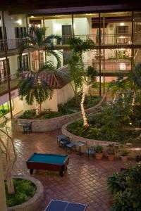 a courtyard with a pool table and palm trees in a building at MCM Elegante Suites Abilene in Abilene