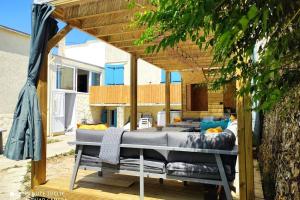 a bed under a pergola on a patio at MER 12 à 14 pers L'Aiguillon sur mer in LʼAiguillon-sur-Mer
