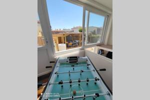 a room with a table in a room with windows at MER 12 à 14 pers L'Aiguillon sur mer in LʼAiguillon-sur-Mer