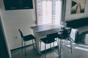 einen Tisch und Stühle in einem Zimmer mit Fenster in der Unterkunft Deluxe Apartment by Prima Lodging in Thessaloniki