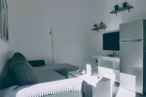 Deluxe Apartment by Prima Lodging في سلانيك: غرفة معيشة مع أريكة وثلاجة