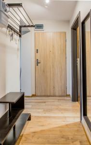 Zimmer mit einem Tisch und einer Holztür in der Unterkunft Apartament u Basi in Danzig