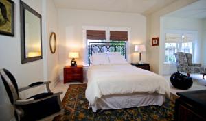 een slaapkamer met een groot wit bed en een stoel bij Refuge in the Heart of Montrose in Houston