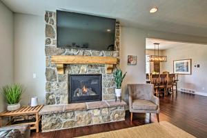 un soggiorno con camino in pietra con tv di Edgewater Townhome about 7 Mi to Snowbasin Resort a Huntsville