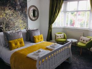 a bedroom with a bed and two chairs and a window at One ninety Boutique Accommodation in Burnham on Sea