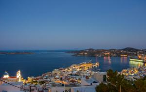 a view of a town in the water at night at TOP SUITES in Ermoupoli