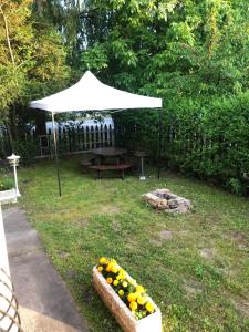 a picnic table under a white umbrella in a yard at ZENITH APARTMAN in Gárdony +3 photos