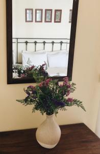eine Vase mit Blumen auf einem Tisch vor einem Spiegel in der Unterkunft Gran Domenica Villa Corfu, Private Pool, Sea View, Garden in Nisaki