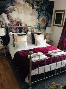 1 dormitorio con 1 cama con pared de flores en One ninety Boutique Accommodation en Burnham on Sea