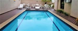 una piscina con patio arredato con tavolo e sedie di Le Premier Residence a Niterói