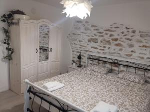 a bedroom with a bed and a stone wall at House Albena in Durankulak