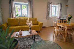 uma sala de estar com um sofá amarelo e uma mesa em Stará Celnice Kvilda em Kvilda