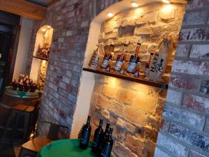 a bar with bottles on a brick wall at AnaCapri Gästehaus Girona in Ueckermünde