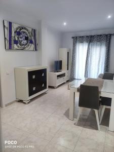 uma sala de estar com uma mesa e uma sala de jantar em Apartamentos el rebalaje em Roquetas de Mar