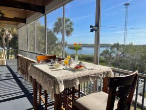 a dining table on a balcony with a view of the water at Crystal River Lullaby B&B in Crystal River