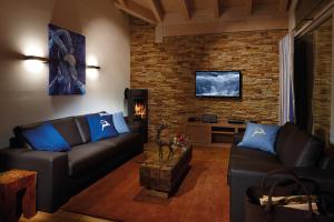 a living room with leather couches and a brick wall at Apartments am alten Rathaus in Oberstdorf