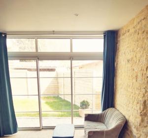 a living room with a large window and a chair at Villa kahlo Omaha Beach in Colleville-sur-Mer