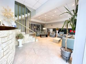 a lobby with couches and a potted plant at Hotel Pighi in Kriopigi