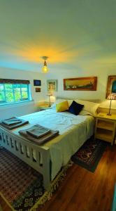 um quarto com uma grande cama branca e duas mesas em Charming Victorian Coach House em Jordanstown