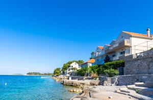 a building on the shore of a body of water at Balkun in Maslinica