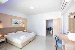 a bedroom with a bed and a table and chairs at Bellini Hotel in Ayia Napa