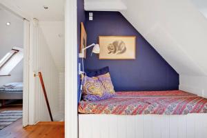 Cama en habitación con pared azul en Hyggeligt gammelt fiskerhus i Marstal en Marstal