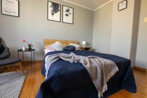 um quarto com uma cama com um cobertor azul em Apartament Cicha em Rzeszów