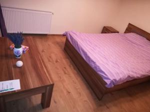 een slaapkamer met een bed en een houten vloer bij Untold 2024 - 3-room apartment with garden for 6-8 person, 2 private parking in Cluj-Napoca