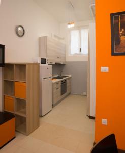 cocina con nevera blanca y pared de color naranja en Il Borgo appartamento Clelia, en Parma