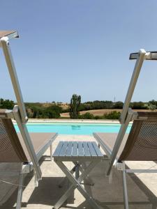 a picnic table and two chairs next to a swimming pool at Villa Rina in Pesaro