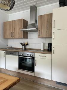 a kitchen with white cabinets and an oven in it at Appartement 5 Willingen in Willingen