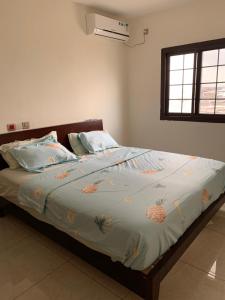 a bedroom with a bed with pineapple sheets and a window at Appartement chic et moderne in Douala