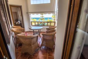 einen Balkon mit Stühlen, einem Tisch und Meerblick in der Unterkunft Appartement Marina Beach - Belle Vue in Mʼdik