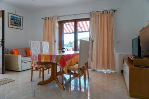 a dining room with a table with chairs and a window at Villa Cvita in Lumbarda