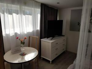 a room with a dresser with a television on it at Guesthouse Henia Bed&Spas in Selfoss