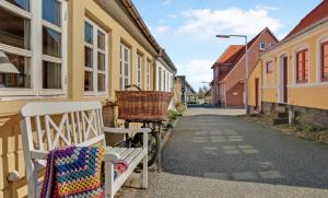 un banco blanco sentado en una calle al lado de los edificios en Hyggeligt gammelt fiskerhus i Marstal, en Marstal