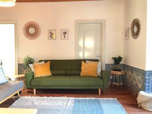 a green couch in a living room with orange pillows at Apartments Center Castelo de São Jorge in Lisbon