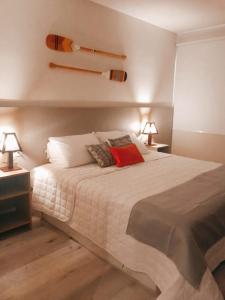 um quarto com uma grande cama branca e 2 candeeiros em POUSADA ATALAIA NORONHA em Fernando de Noronha