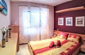a bedroom with a bed with red and yellow pillows at FRAMANTIS App No 6 in Costa Calma