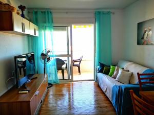 ein Wohnzimmer mit einem Sofa und einer Glasschiebetür in der Unterkunft Alta Vista - apartamento con 2 dormitorios y vista al mar in Torrevieja