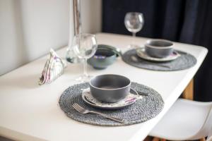 a table with two cups and plates and wine glasses at Apartament Cicha in Rzeszów