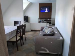 Tímár Apartman Eger في إغير: غرفة معيشة مع أريكة وطاولة