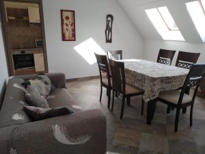 Tímár Apartman Eger في إغير: غرفة معيشة مع طاولة وكراسي وأريكة