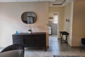 ein Wohnzimmer mit einem Spiegel und einem Tisch in der Unterkunft Koena Court (Unit 2) - With Uncapped Fiber Wi-Fi in Midrand