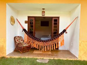 una hamaca en el porche de una casa en Pouso do Kite Pousada Flecheiras, en Flecheiras