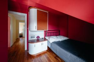 a red bedroom with a bed and a red wall at Abramówka - dom z jacuzzi in Polańczyk