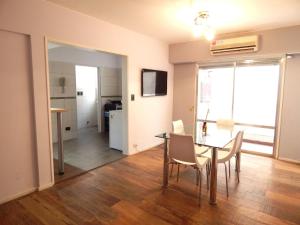 comedor con mesa y sillas y cocina en Apartamento en Rosario