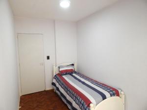 a small bedroom with a bed in a white room at Apartamento in Rosario