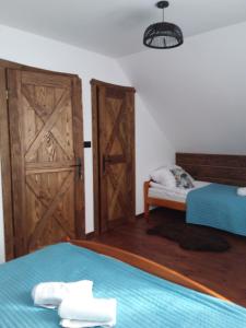 Zimmer mit 2 Betten und einer offenen Tür in der Unterkunft Dom Gościnny Poza Czasem in Żubracze